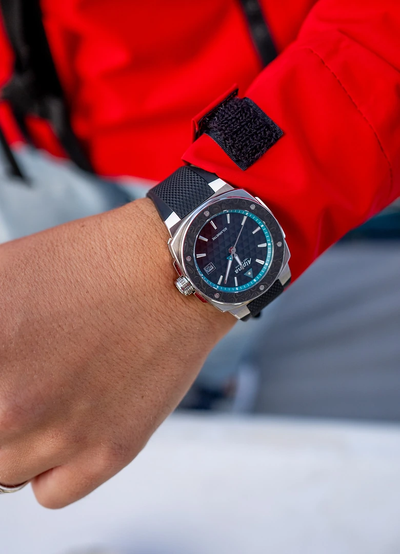 L'Alpina Alpiner Extreme Solarmetre Route du Rhum portée au poignet sur une veste de quart rouge