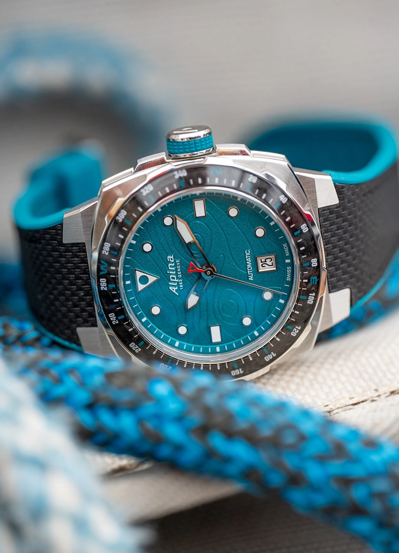 L'Alpina Seastrong Diver Extreme Route du Rhum de trois quarts sur un cordage bleu, lunette compas et cadran turquoise