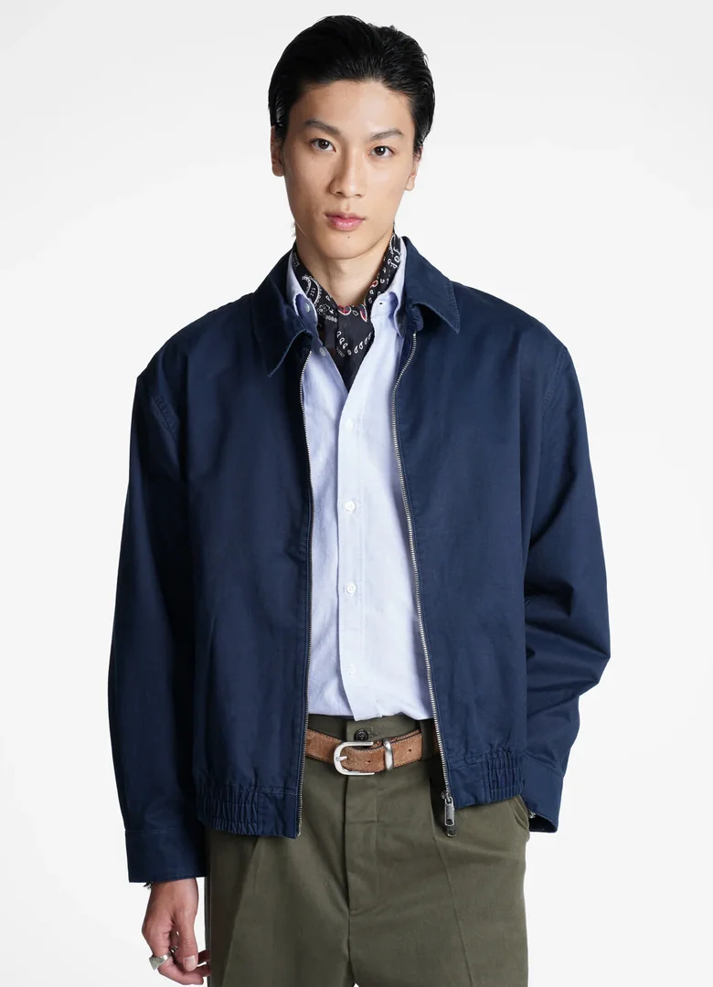 Veste homme Baracuta G18 bleu marine zippée, portée sur une chemise bleue et un foulard