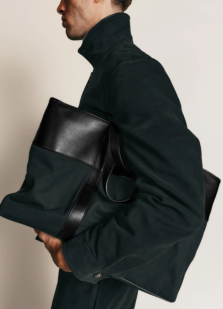 Le cabas 24h Hast x Le Tanneur en toile verte et cuir noir, porté à l’épaule