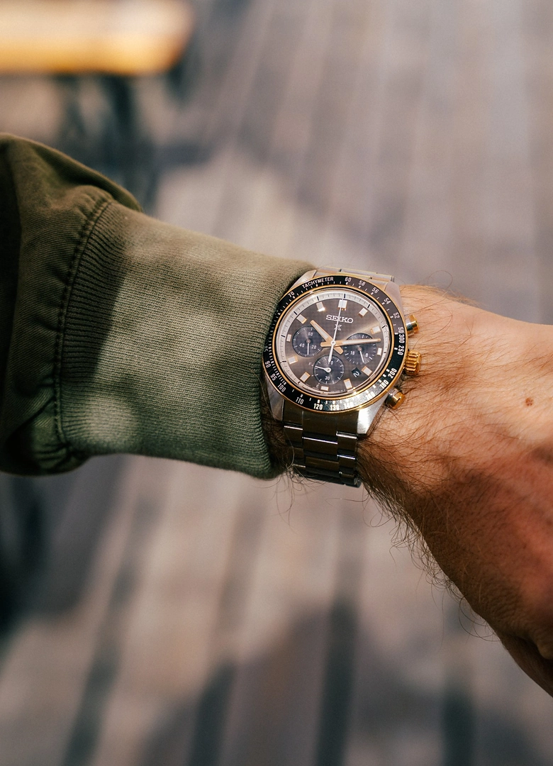 La Seiko Prospex Speedtimer SSC941 au poignet, cadran noir et cerclage doré, sous une manche kaki