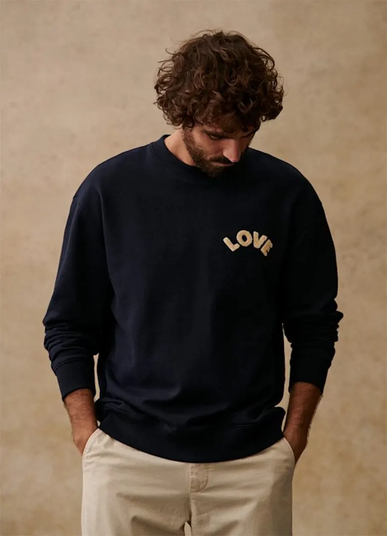 Sweatshirt homme Octobre Éditions Love bleu marine brodé, porté avec un pantalon beige