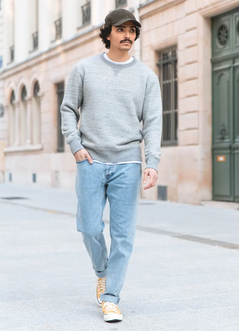 Sweat homme LePantalon jaspé gris chiné à col V, porté avec un jean clair et une casquette dans la rue
